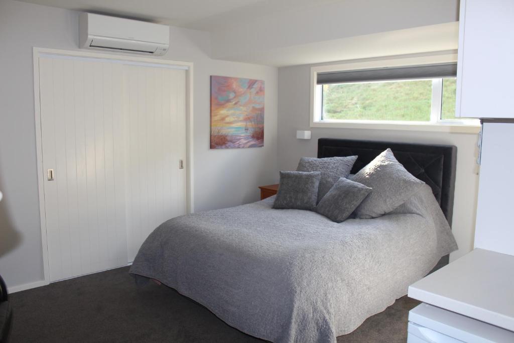 皇后镇Blue Skies Guest Accommodation的一间卧室设有一张床和一个窗口