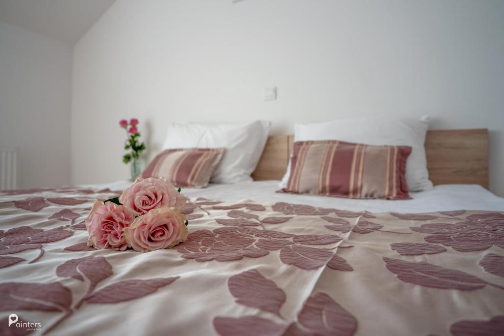 NetretićHotel Amarilis的两朵粉红色玫瑰坐在床上