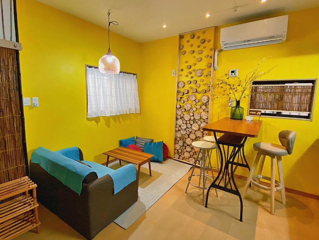 横滨Lucy's House横浜中華街 House5的黄色的客厅配有沙发和桌子