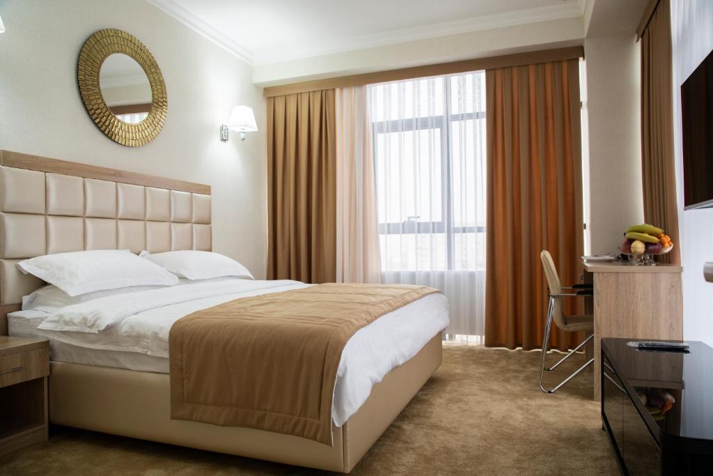 塔什干VELARA HOTEL的配有一张大床和镜子的酒店客房