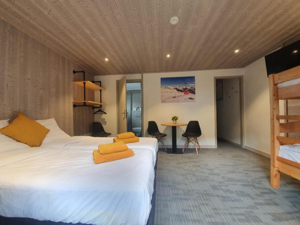 谷雪维尔Lodge Les Merisiers的酒店客房配有两张床和一张书桌