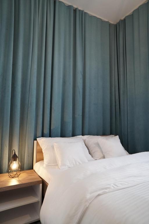 科沙林Stary Koszalin Hostel &amp; Hotel Services的有两张床和蓝色窗帘的卧室