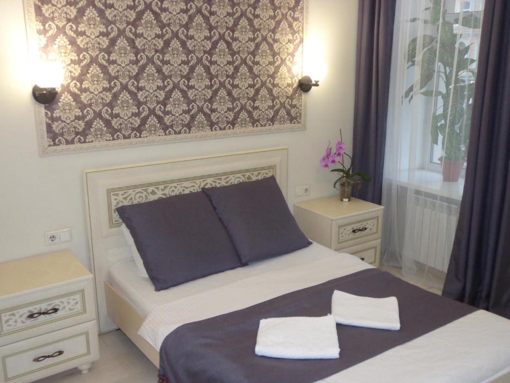圣彼得堡Mushroom24的一间卧室配有一张带两条白色毛巾的床