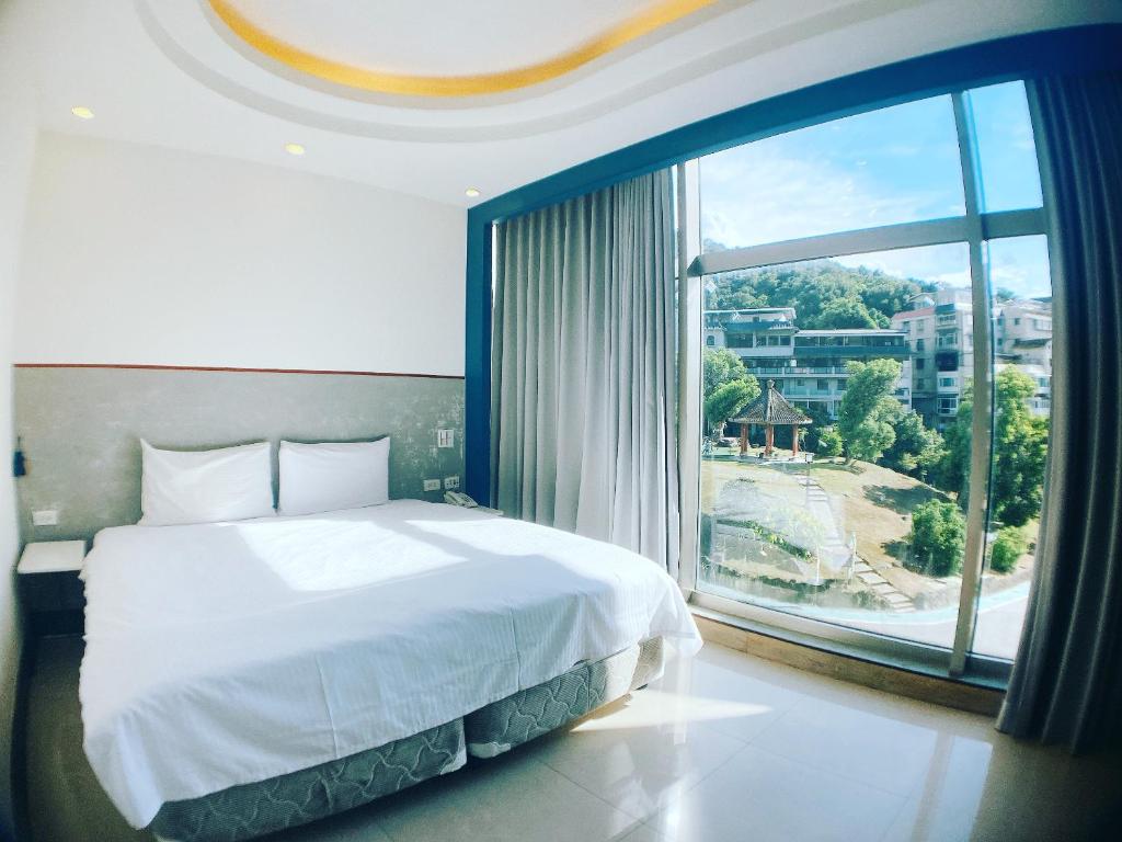 台北水都溫泉會館 的一间卧室设有一张大床和一个大窗户
