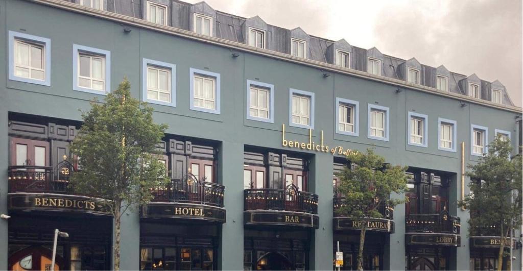 贝尔法斯特本尼迪克特酒店的一座大型蓝色建筑,前面有树木