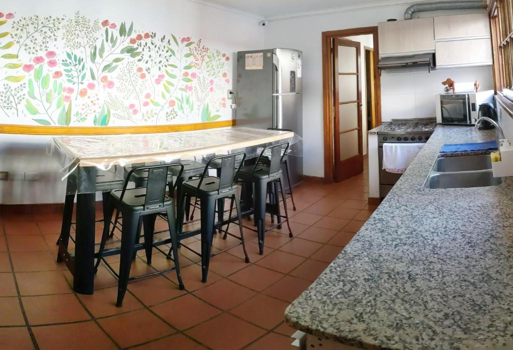 马德普拉塔Hostel Sauce的厨房设有带凳子和台面的酒吧