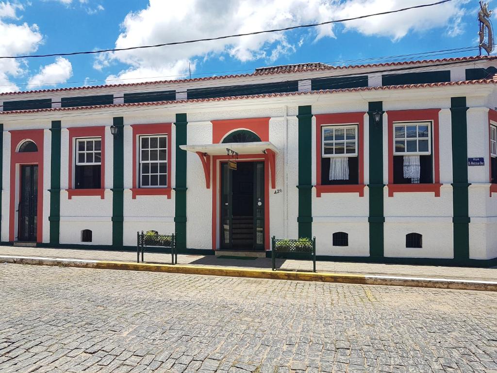 兰巴里Pousada do Duque的白色的大建筑,红色和绿色的镶边