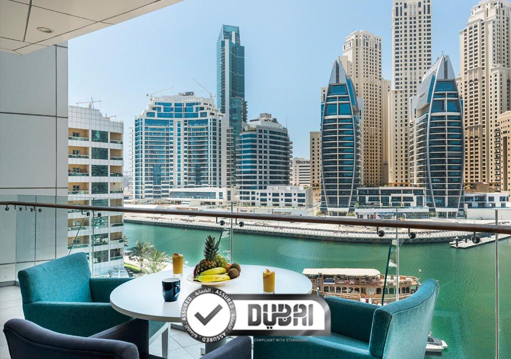 迪拜Jannah Marina Hotel Apartments的一张桌子和椅子,享有城市天际线的美景