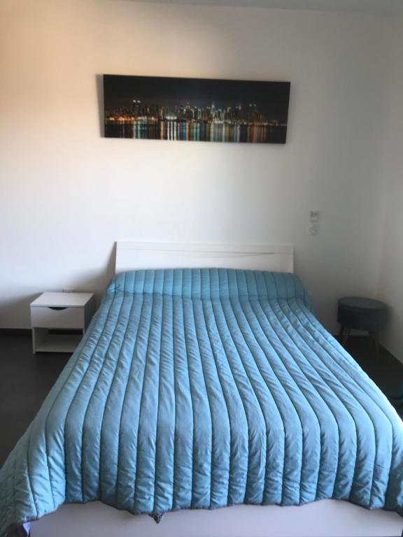 科尔特charmant studio dans résidence neuve et calme的卧室内的一张蓝色棉被