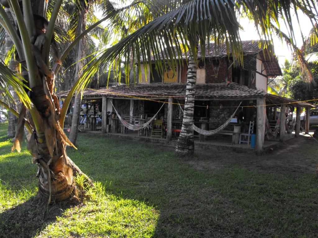 库穆鲁沙蒂巴Hospedaria Cumuruxatiba的前面有棕榈树的建筑
