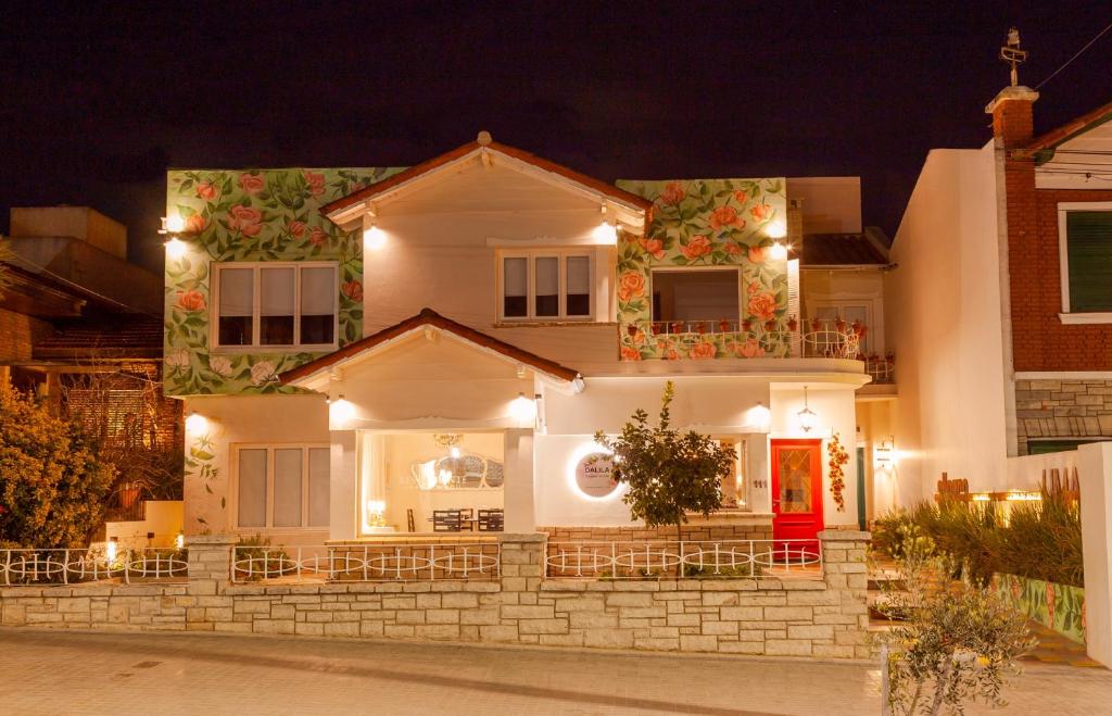 坦迪尔Allegra Dalila Casa Hotel-Arte的白色的房子,晚上有红色的门