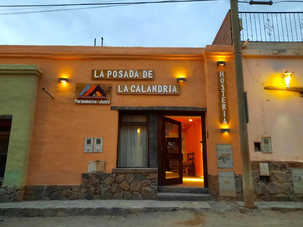 普尔马马尔卡La Posada de la Calandria的一座有标志的建筑,上面写着读到la piscola be laçoglania的标志