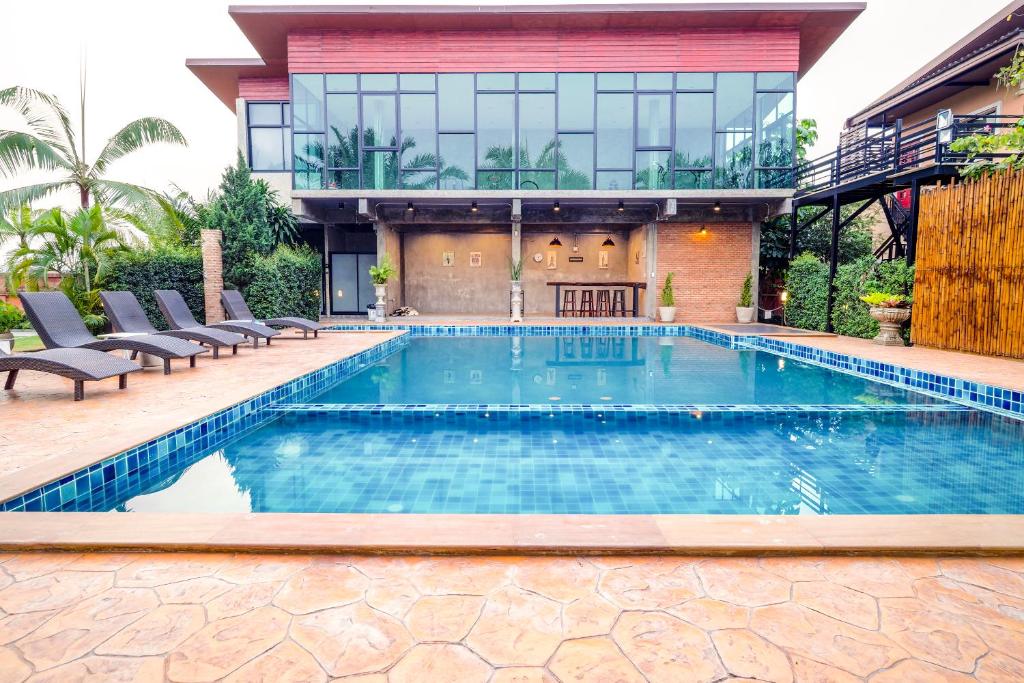 班杜Capital O 727 Be One Resort的房屋前的游泳池
