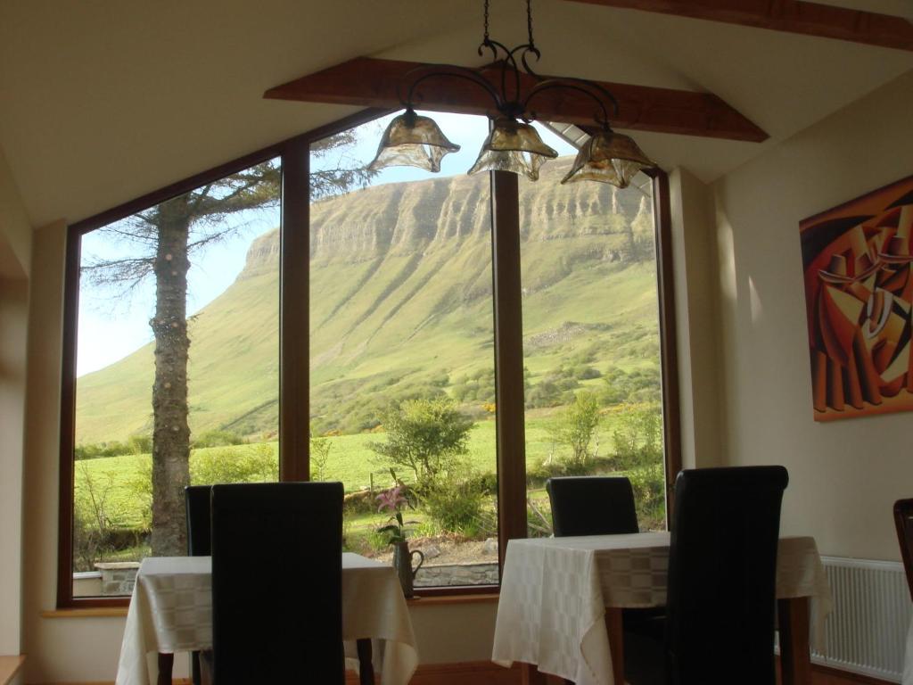 Drumcliff本布尔本农舍住宿加早餐旅馆的一间透过窗户可欣赏到山景的用餐室