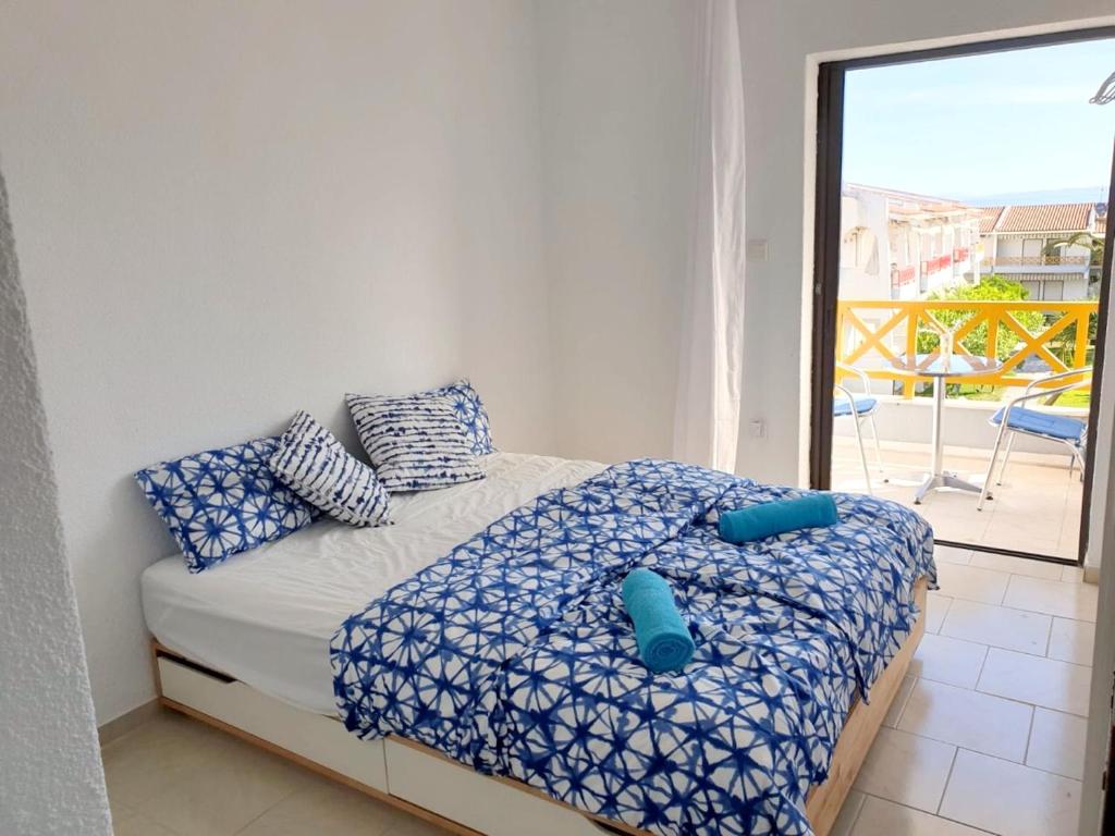 卡尼奥提One bedroom apartement with sea view balcony and wifi at Chaniotis的一间卧室配有一张带蓝色枕头的床和一个阳台
