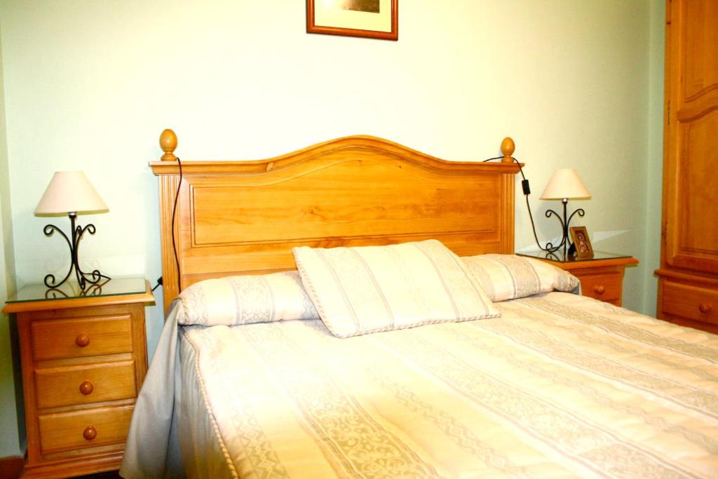 拉伊鲁埃拉3 bedrooms appartement with shared pool and enclosed garden at La Iruela的一间卧室配有一张带白色枕头的床和两盏灯。