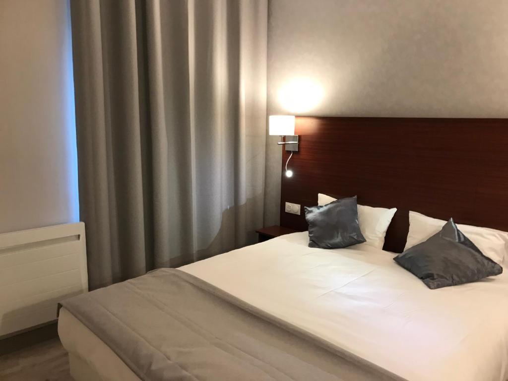 巴黎贝尔松驿站酒店的一间卧室配有一张带两个枕头的床