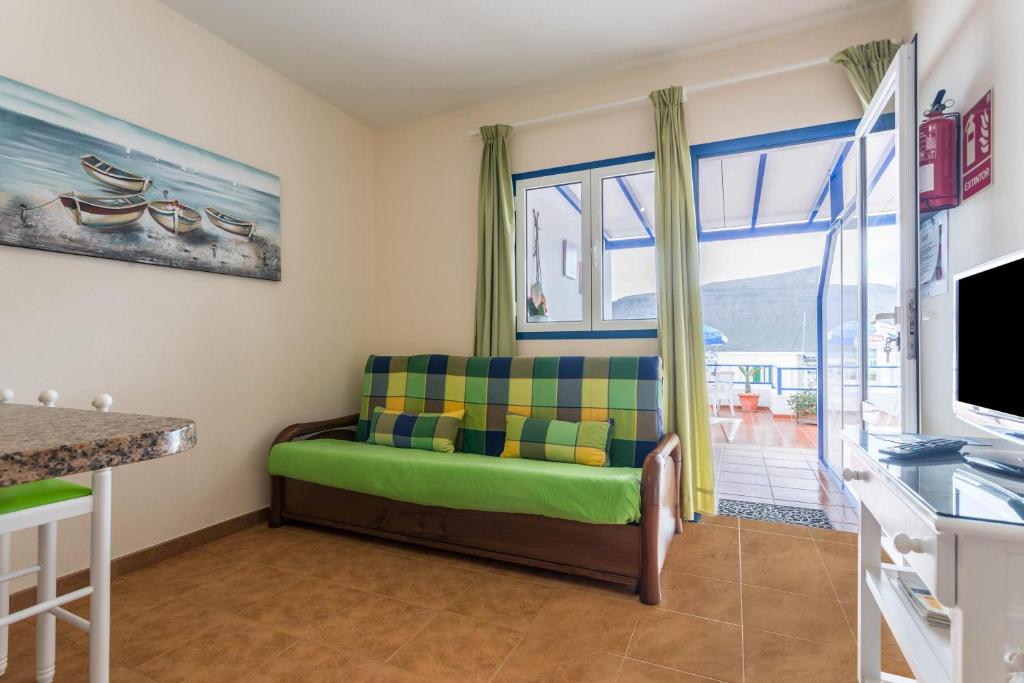 塞博河畔卡莱塔El Sombrerito 5的客厅设有绿色沙发和窗户。