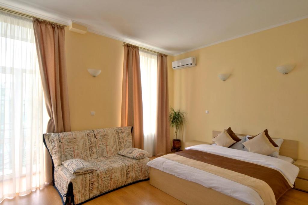 基辅Heart Kyiv Apart-Hotel的一间卧室配有一张床、一张沙发和窗户。