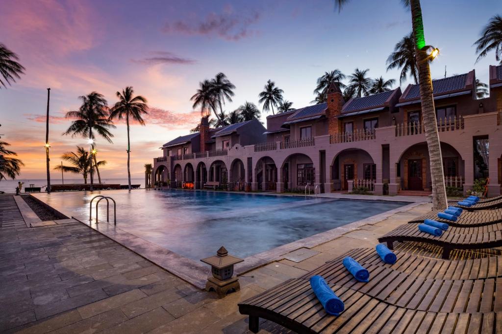 美奈Le VIVA Resort Mui Ne的一个带游泳池和棕榈树的度假村