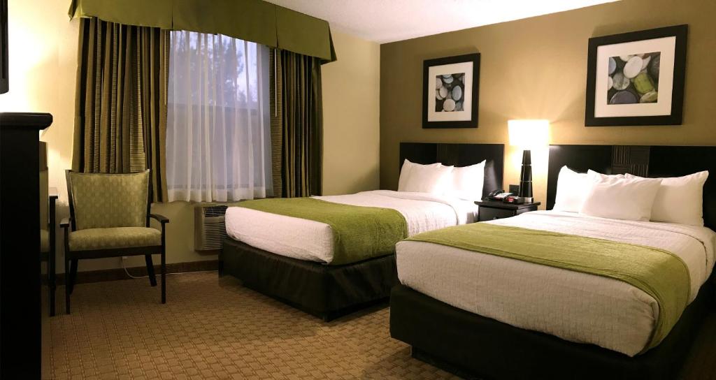 图巴城NavajoLand Hotel的酒店客房,配有两张床和椅子