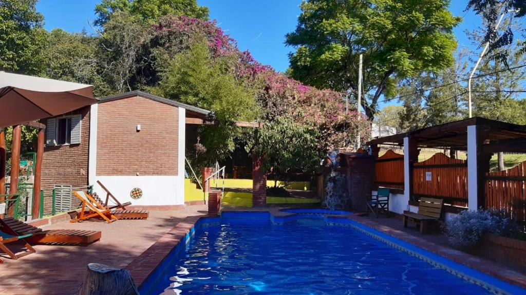 维拉乌奎扎大树宾馆的一座带房子的庭院内的游泳池