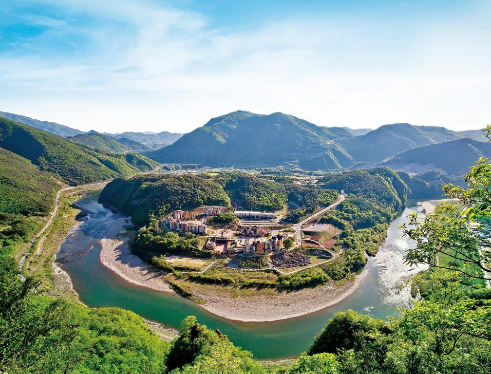 宁越Tops10 Resort Donggang Cistar的享有河边山丘上房屋的空中景致