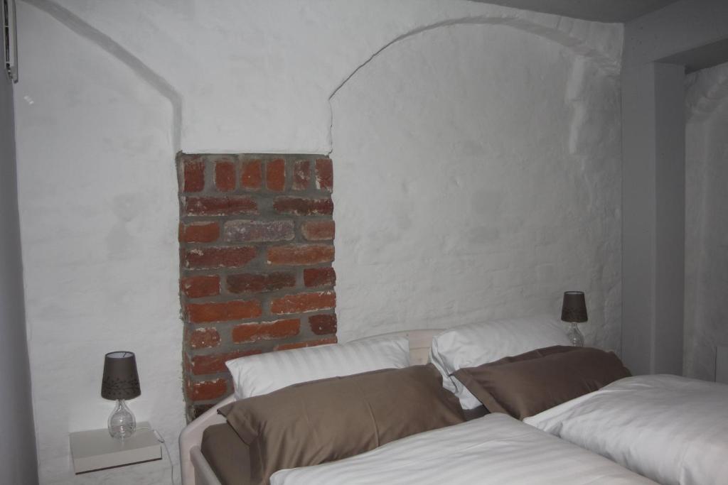 施特拉尔松德菲林蒙科49公寓的一间设有两张白色床铺和砖墙的房间