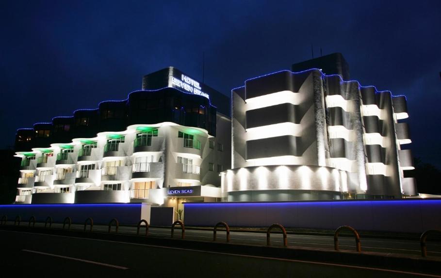 大洗町Hotel Oarai Seven Seas(Adult Only)的两栋建筑晚上有灯