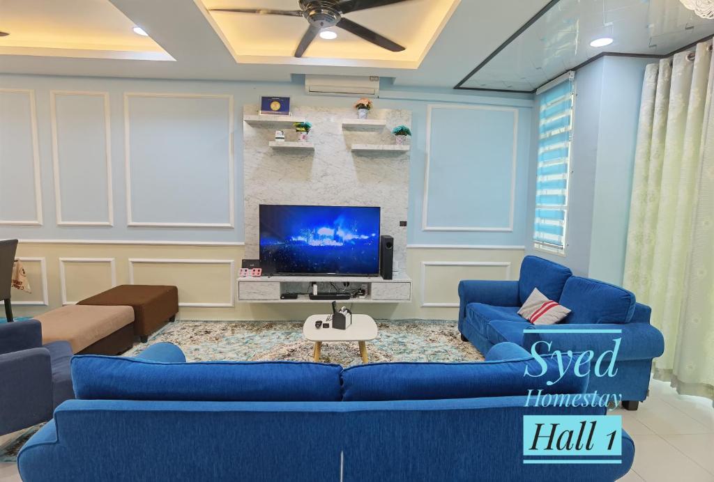 亚娄Syed Homestay Arau的客厅配有蓝色的沙发和电视