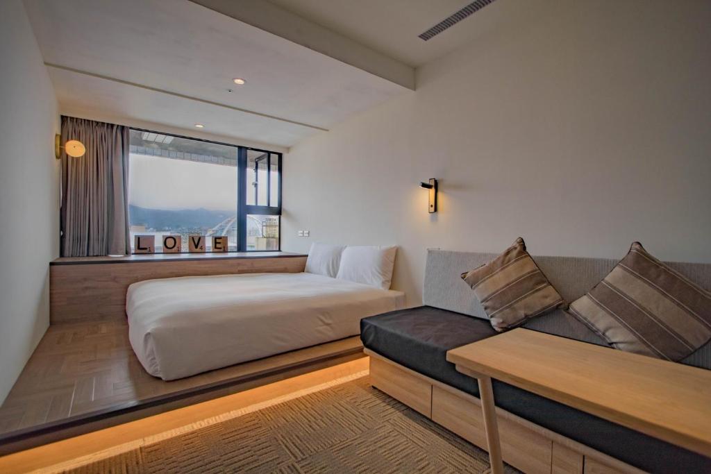 台北小公馆人文旅舍的一间卧室配有一张床、一张沙发和一个窗口
