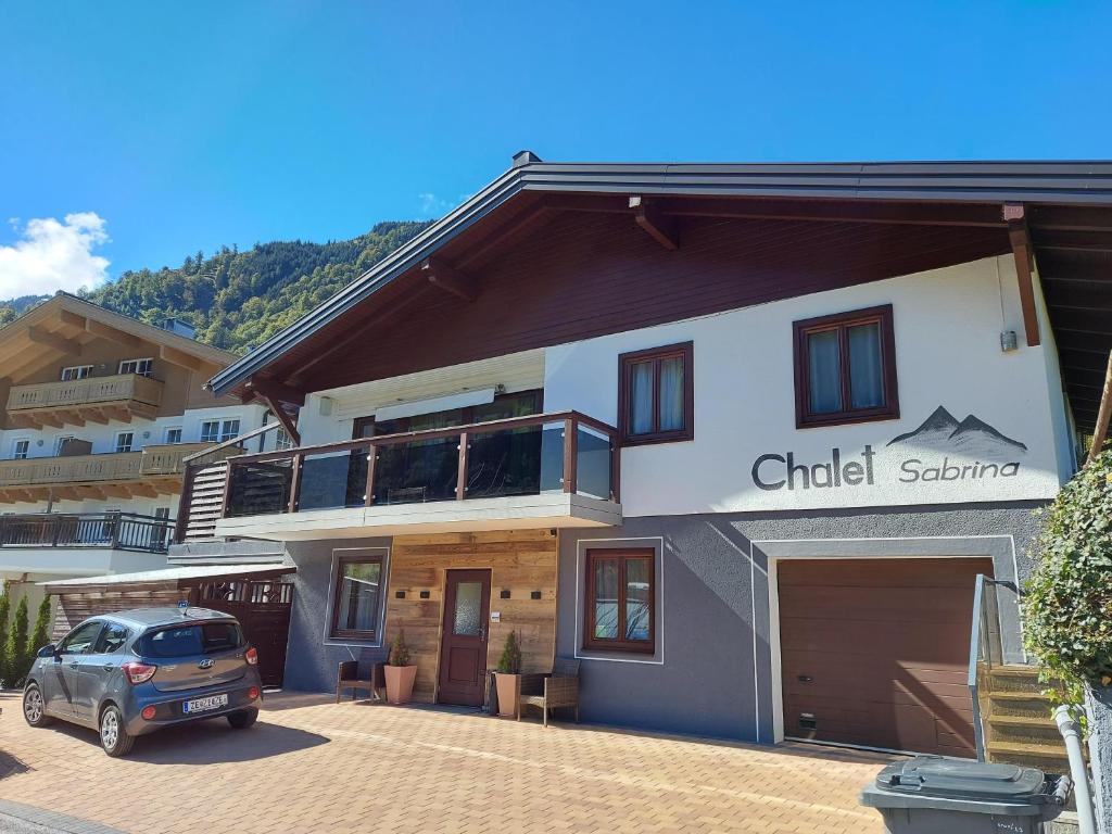 卡普伦Chalet Sabrina mit Außenpool im Sommer的前面有停车位的建筑