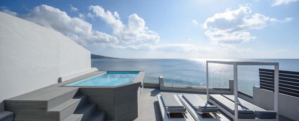 阿克罗蒂里Sublime Villa & Caves的一个带游泳池和椅子的阳台,享有海景