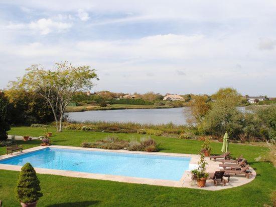 南安普敦Villa Noyaan - Luxury with pool的一座游泳池,位于带湖泊的庭院内