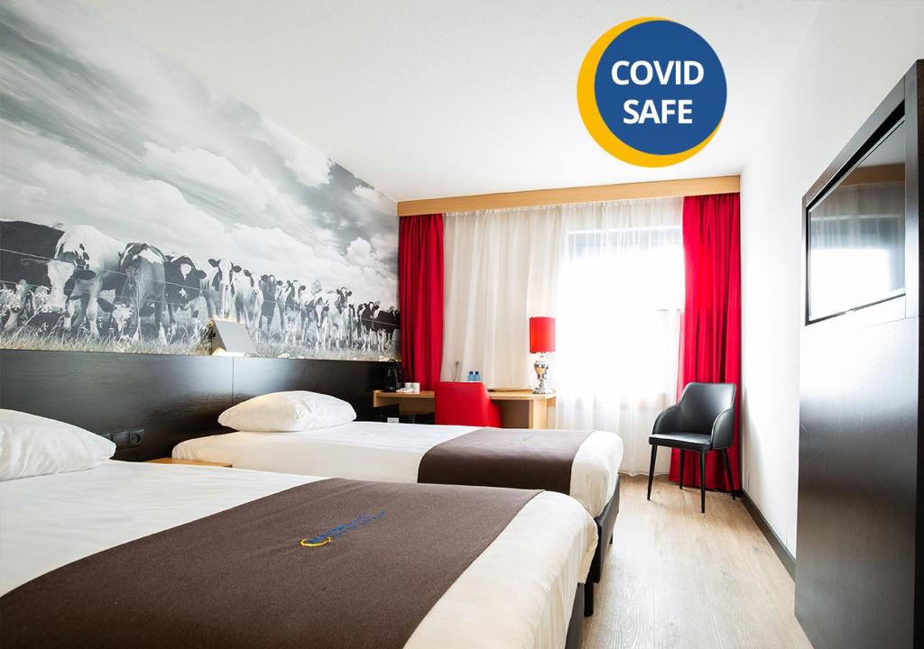 祖特尔梅尔祖特尔梅尔巴斯蒂欧酒店的酒店客房设有两张床和一个可读安全保险箱的标志