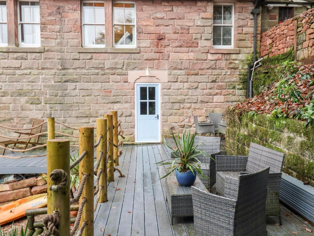利克Horton Lodge Boathouse的一个带椅子的庭院、白色的门和砖砌建筑