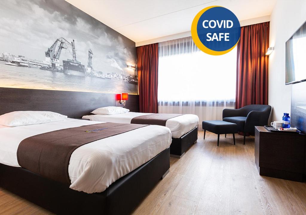鹿特丹鹿特丹亚历山大堡垒酒店 的酒店客房设有两张床和一个可控制保险箱的标志