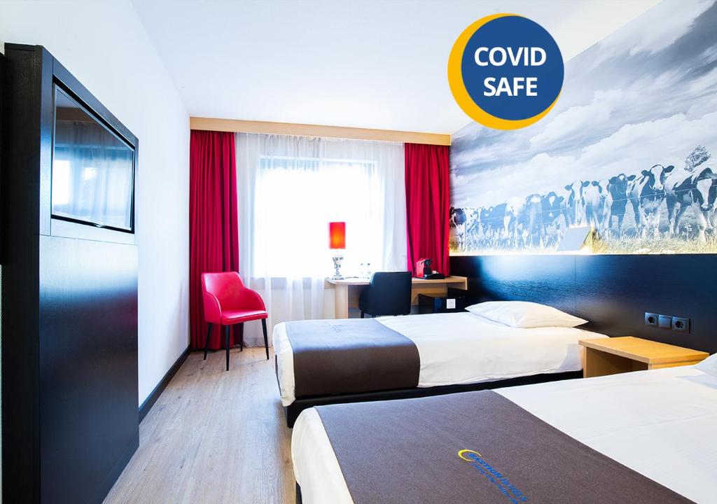 罗森达尔巴斯琛哥罗普酒店的酒店客房设有两张床和一个可读安全保险箱的标志