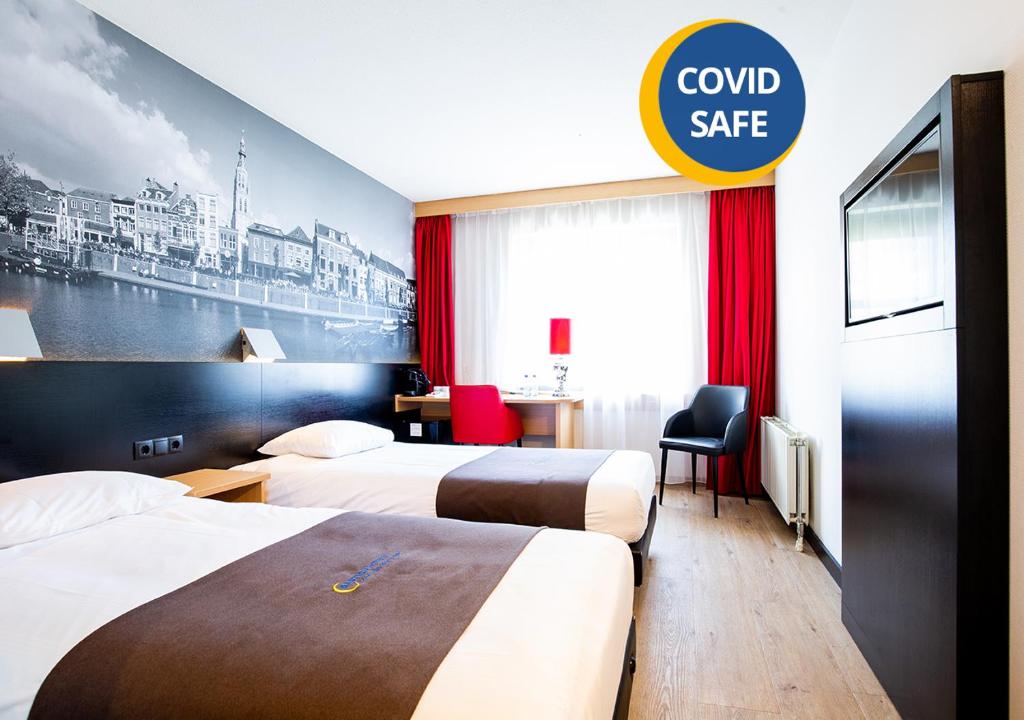 布雷达巴斯通布雷达酒店的酒店客房设有两张床和一个可控制保险箱的标志