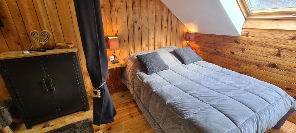 圣让德莫里耶讷琪琪&可可民宿酒店的卧室配有一张床铺,位于带木墙的房间内