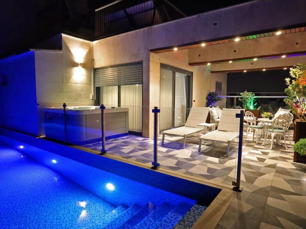内坦亚Luxury Rooftop Apartment in Netanya的一座带游泳池和庭院的房子