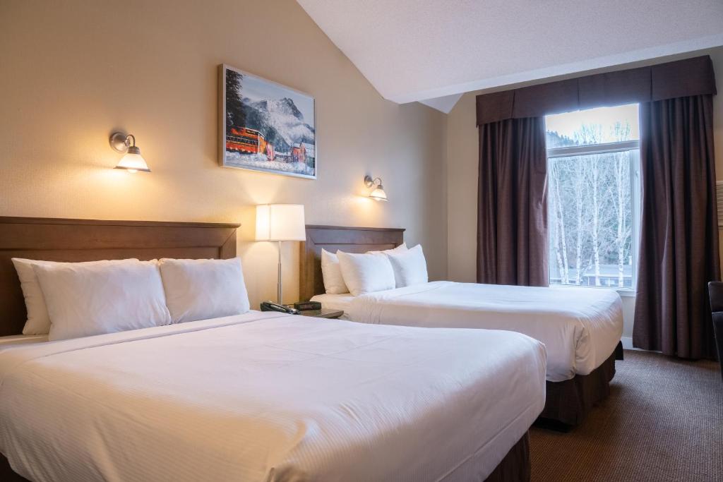 班夫欧文山地酒店的酒店客房设有两张床和窗户。