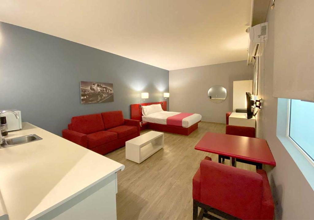 墨西哥城Hotel MX forum buenavista的一间配备有红色沙发和床的小客厅