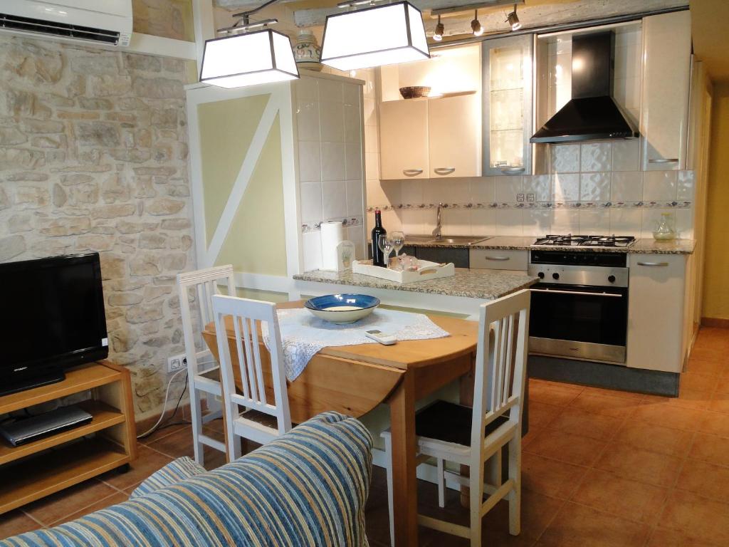 Portell卡尔何塞普公寓的厨房配有桌子和炉灶。 顶部烤箱
