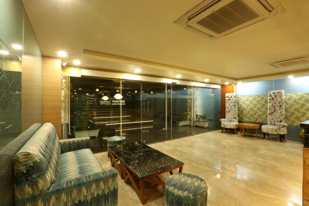 古尔冈Hotel Omega - Gurgaon Central的大堂配有沙发和桌椅
