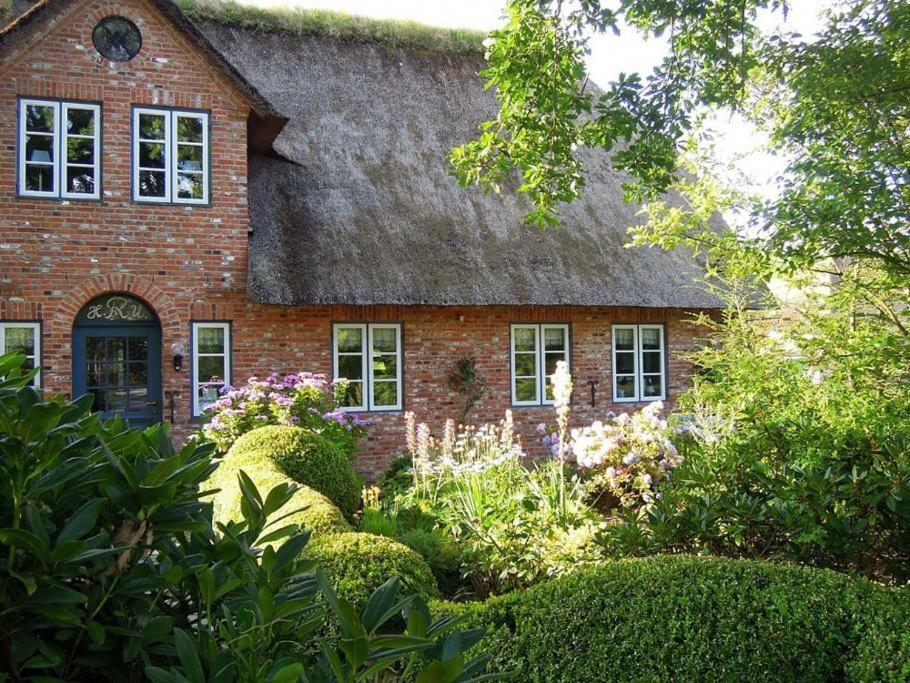 胡苏姆Reethus Schobüll的一座带草屋顶的老砖屋