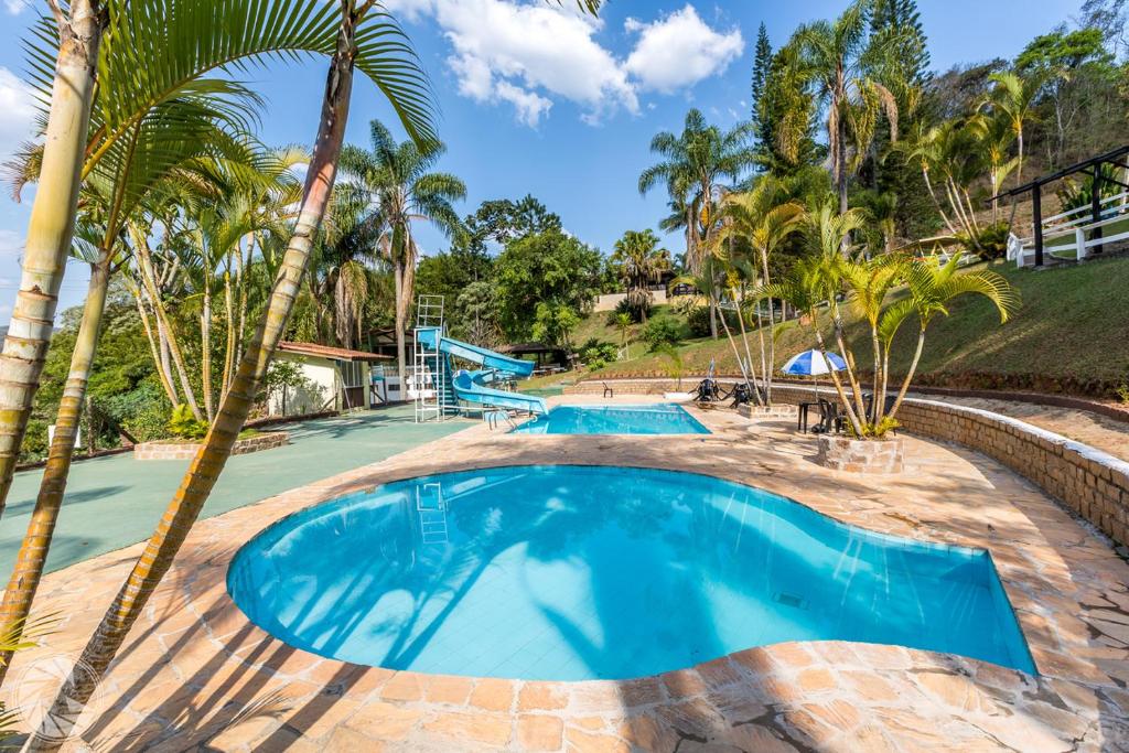 阿蒂巴亚Pousada Atibaia的度假村内棕榈树游泳池