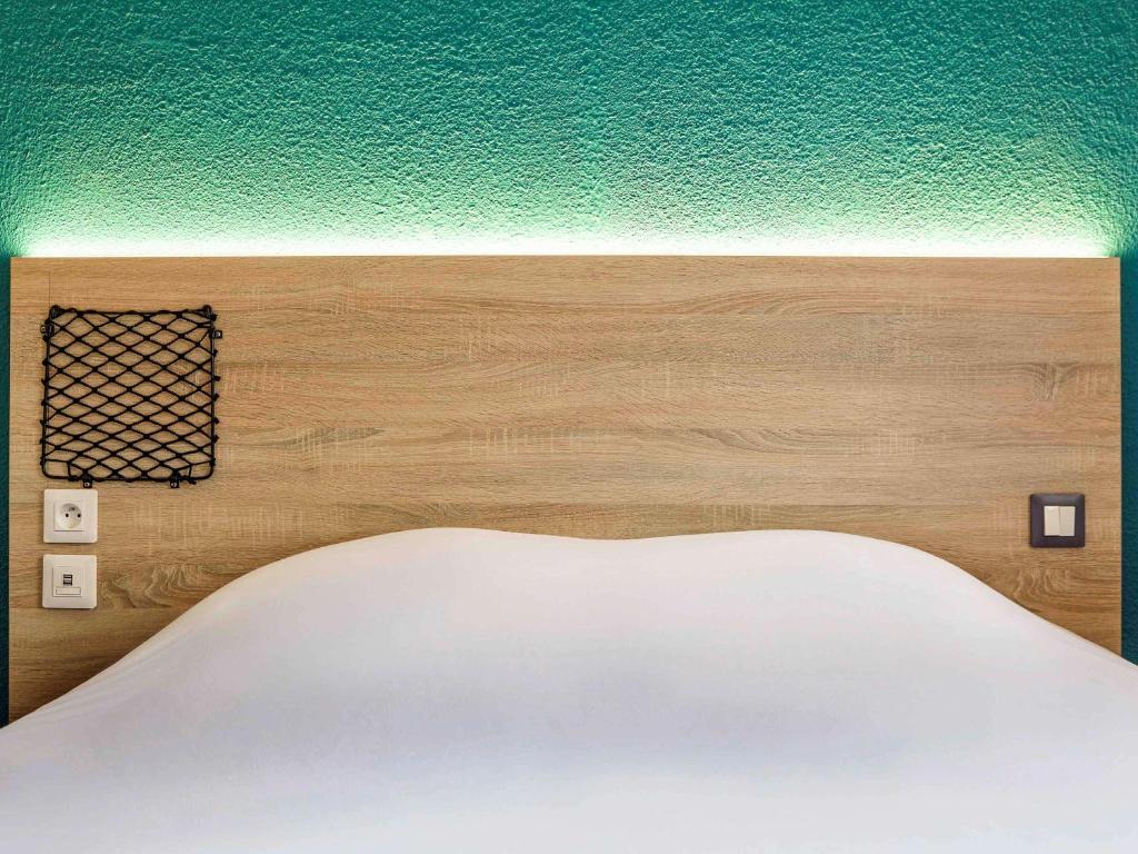 保拉扎克chicÔtel Périgueux Boulazac的一张带绿色墙壁的床的床头板
