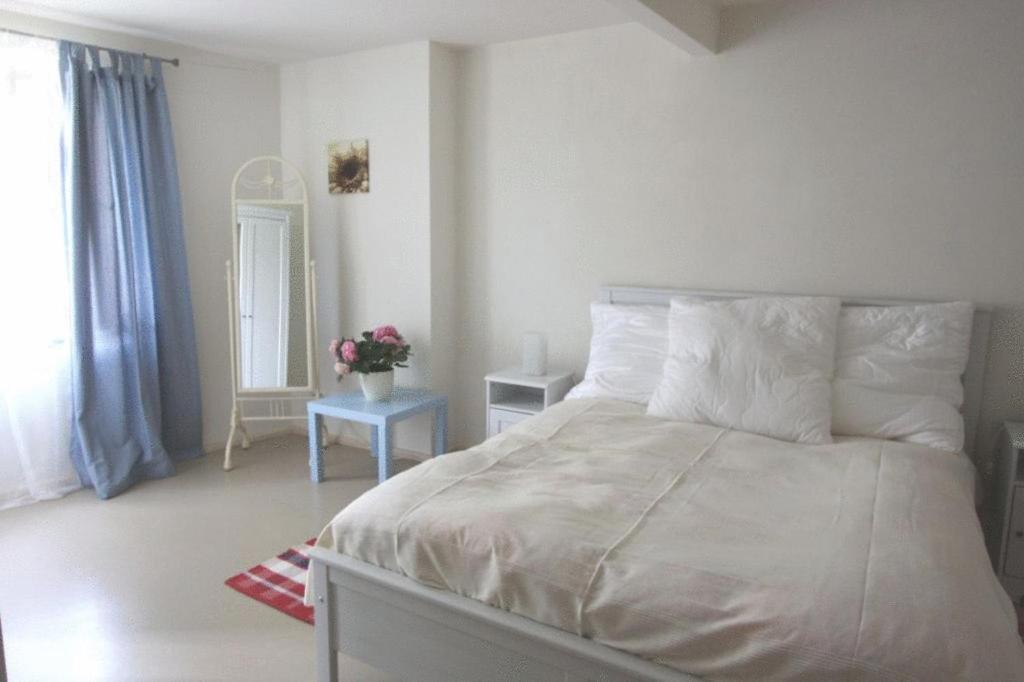 奎德林堡天堂&地狱自助式公寓酒店的卧室配有一张带白色床单和枕头的大床。