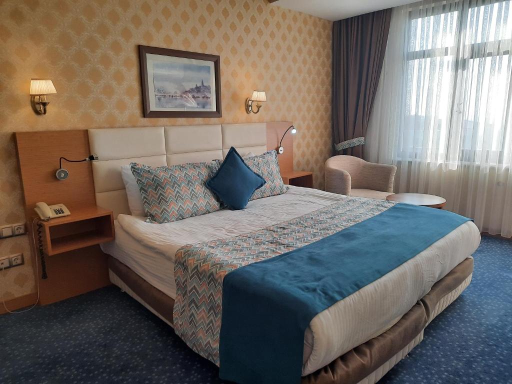 迪亚巴克尔迪亚巴克尔广场酒店的酒店客房带一张大床和一把椅子